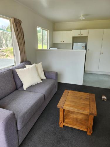 a living room with a couch and a coffee table at Whalers retreat in Pukenui