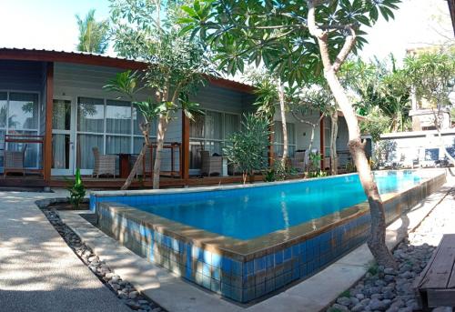 a swimming pool in front of a house at Villa PhyPhy in Gili Trawangan