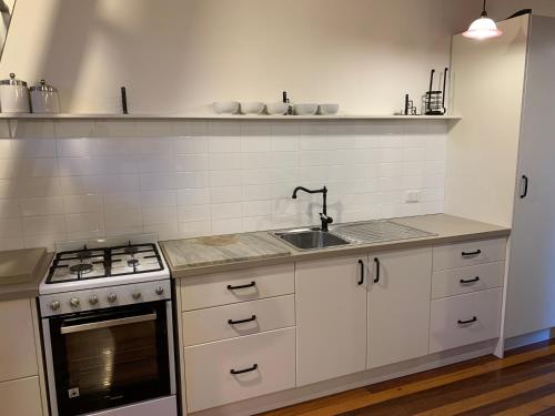 a kitchen with a sink and a stove at Garden studio in Glenbrook