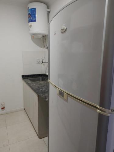 um frigorífico branco numa cozinha com um lavatório em punto de encuentro em Corrientes