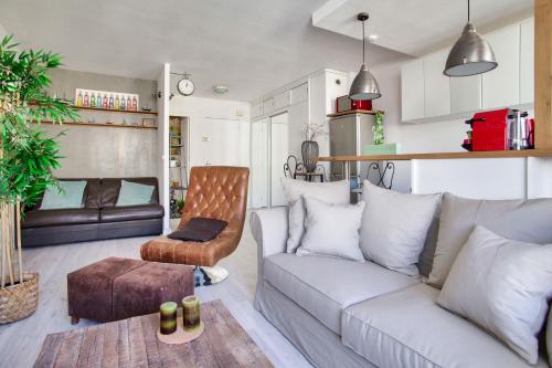 ein Wohnzimmer mit einem Sofa und einem Stuhl in der Unterkunft Studio Republique Pierre Levé in Paris