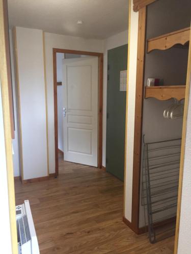 a hallway with a white door and a closet at Silènes B33 à Chamrousse 1700 aux Domaines de l'Arselle in Chamrousse