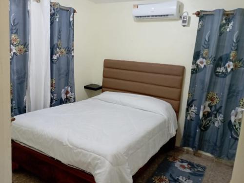 a bedroom with a bed with blue drapes at Lugar encantador en el Malecón Paraíso, Barahona. in Paraíso