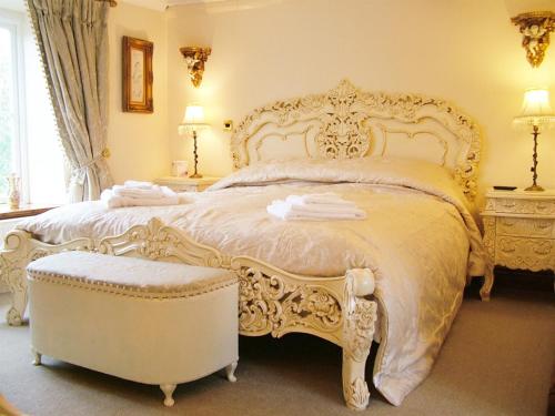 a bedroom with a large white bed and a chair at Melody House in Fakenham