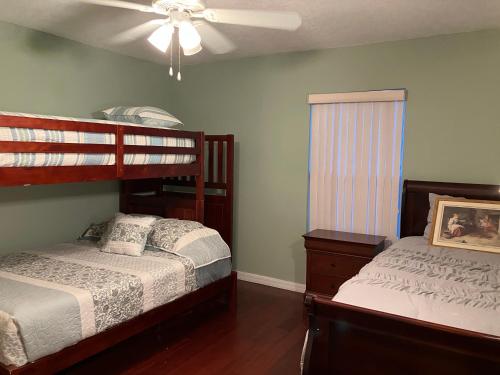 1 dormitorio con 2 camas y ventilador de techo en Nature Friendly en White City