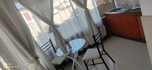 a table and chairs in a room with a window at Las Cabañas del Francés in Vallenar