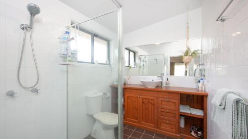 a bathroom with a shower and a toilet and a sink at Hamilton House in Yamba