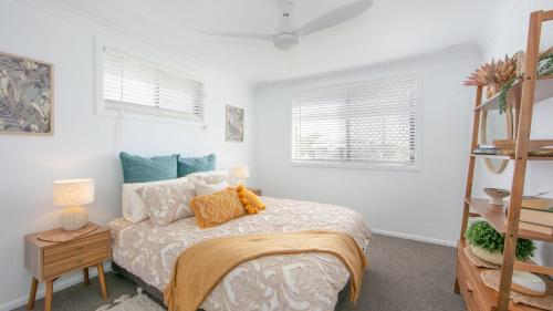 a bedroom with a bed and two windows at Hamilton House in Yamba