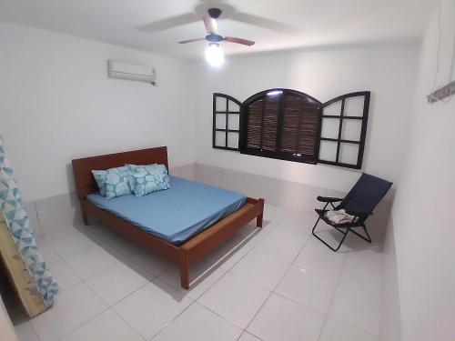 - une chambre avec un lit et une chaise dans l'établissement CASA MATTOS, à São Pedro da Aldeia