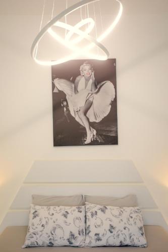 a chandelier above a bed with a picture of a fairy at Hotel Paradise Road in Kutaisi