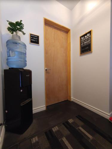 a hallway with a door and a plant on top of a refrigerator at Les Chalets Double K # 1 in Saint-Alexis-des-Monts