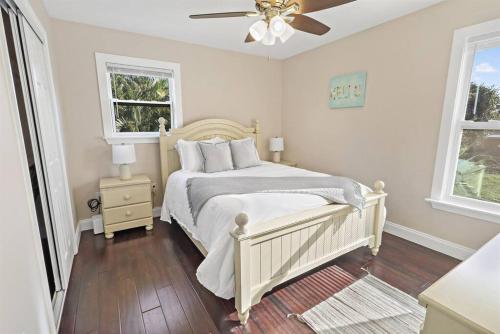 a white bedroom with a bed and a ceiling fan at Casa Arena Relaxing Beach House w/ Patio in Vero Beach