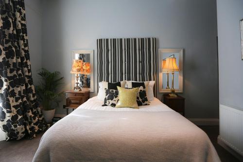 um quarto com uma cama grande e almofadas em The Crown and Sceptre em Londres