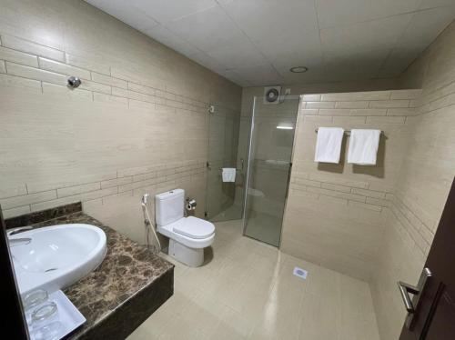 y baño con lavabo, aseo y ducha. en ROYAL HOTEL en Mascate