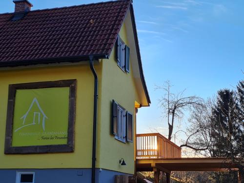 een geel gebouw met een bord aan de zijkant bij Ferienhaus Grabenhansl in Stubenberg