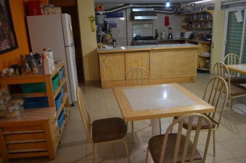 a kitchen with a table and a refrigerator at Hotel Tolotzin in Toluca