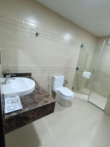 a bathroom with a sink and a toilet and a shower at ROYAL HOTEL in Muscat