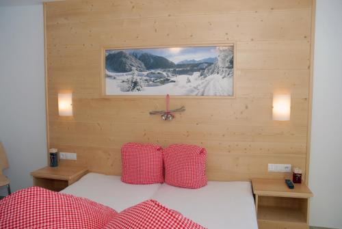 1 dormitorio con 1 cama con almohadas rojas y blancas en Appartements Delano en Umhausen