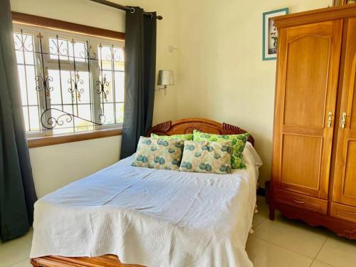 a bedroom with a bed with pillows and a window at Calypso - Maison face au lagon - Trou aux Biches in Trou aux Biches