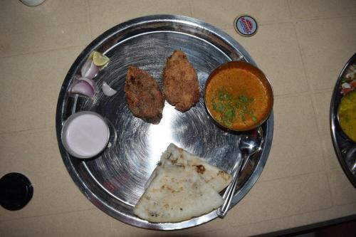 a plate of food with chicken nuggets and a dipping sauce at Suma beach resort in Dapoli