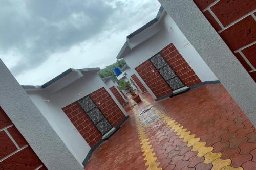 a red brick building with a yellow stripe in front of it at Suma beach resort in Dapoli