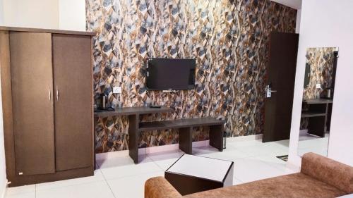 a living room with a tv on a wall at Hotel Bagga Kuteer in Haridwār
