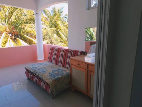 a room with a chair and a desk and a window at House/ Private Pool , wifi, jacuzzi/spa ,security alarm, canal+ near sea in Grand-Baie