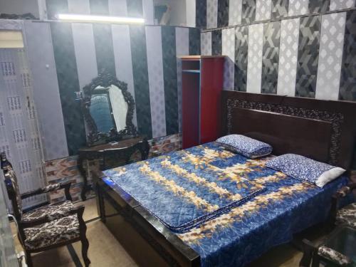 um quarto com uma cama, um espelho e uma cadeira em Doha Guest House 