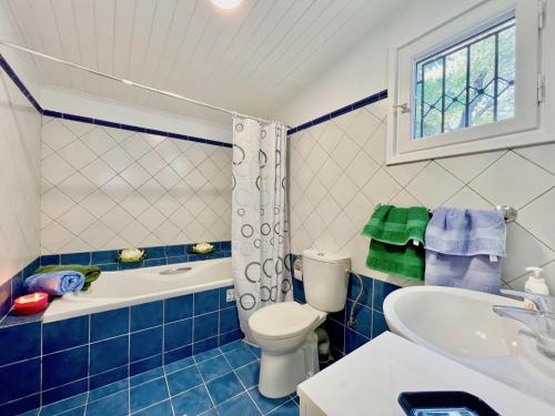 a blue and white bathroom with a toilet and a sink at Apraos Beachfront House by DadoVillas in Apraos