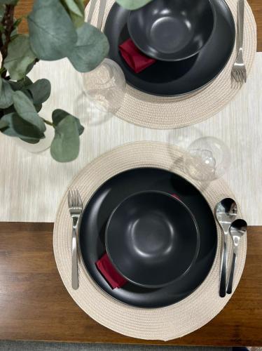 a table topped with two black plates and silverware at Mont Kiara 163 Mall (The Ooak) Private Room in Kuala Lumpur