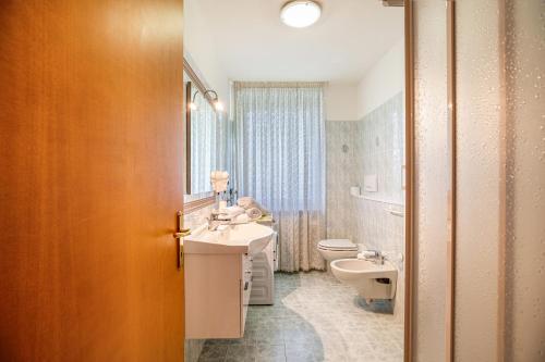 uma casa de banho com um lavatório e um WC em Casa Penasa Appartamento 1 em Commezzadura