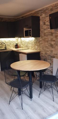 uma mesa de madeira e cadeiras numa cozinha em Appartement Saint Gervais les Bains piscine et vue imprenable Mont Blanc em Saint-Gervais-les-Bains