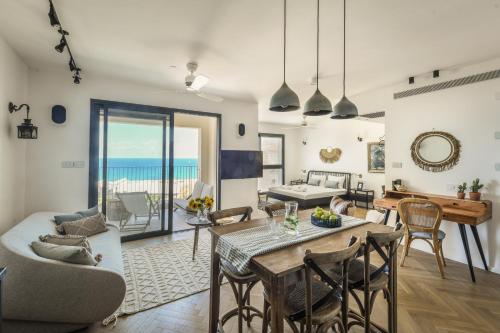 una sala da pranzo e un soggiorno con tavolo e sedie. di Serene Studio Apt w Balcony Overlooking the Sea by Sea N' Rent a Tel Aviv