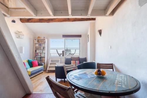 une salle à manger et un salon avec une table et des chaises dans l'établissement Terrasse vue mer & quartier historique Vieux Port, à Marseille