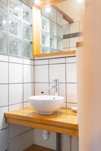 une salle de bain avec un lavabo blanc sur un comptoir en bois dans l'établissement Terrasse vue mer & quartier historique Vieux Port, à Marseille
