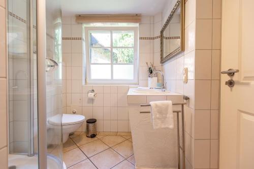 La salle de bains est pourvue de toilettes, d'un lavabo et d'une fenêtre. dans l'établissement Künstlerhaus Rosenthal 02, à Ahrenshoop