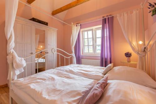 - un lit blanc à baldaquin dans une chambre dans l'établissement Künstlerhaus Rosenthal 02, à Ahrenshoop
