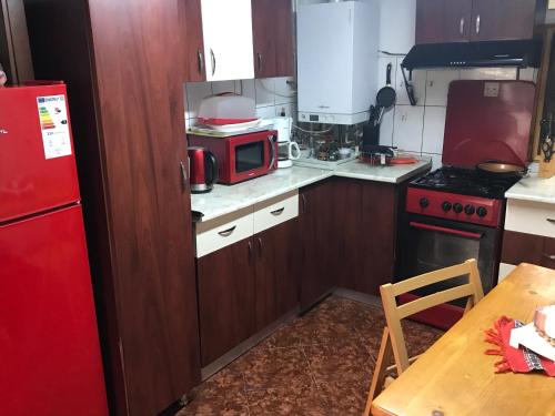 cocina con microondas rojo y nevera roja en Cabana Trei Brazi Dambovita en Bezdead