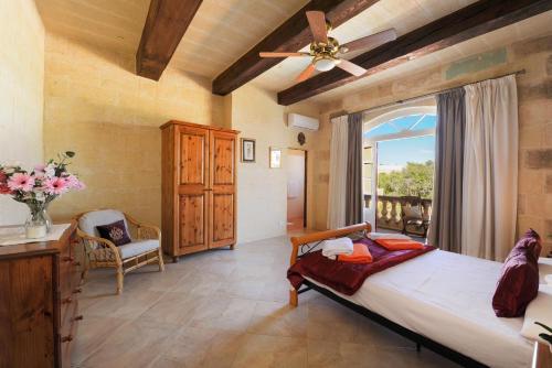 Un dormitorio con una cama grande y una ventana en Narcisa Holiday Home en Nadur