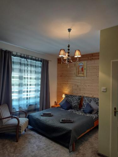 a bedroom with a large bed and a chandelier at Hámori Álom in Miskolc