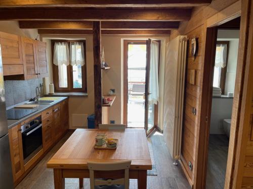 a kitchen with wooden cabinets and a wooden table at Affittacamere Belvedere in Sordevolo