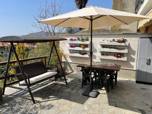 an umbrella and a table and chairs on a patio at Affittacamere Belvedere in Sordevolo