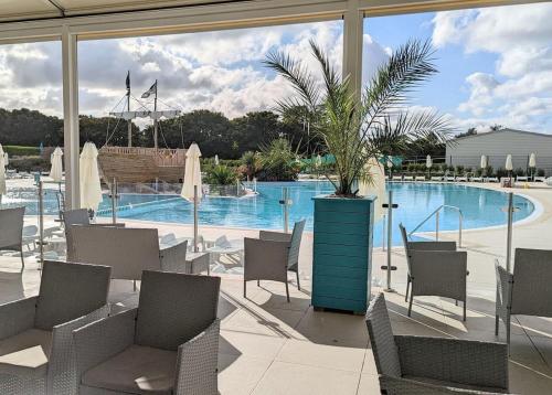 a pool with chairs and a potted plant in a patio at Monkey Tree Holiday Park in Newquay