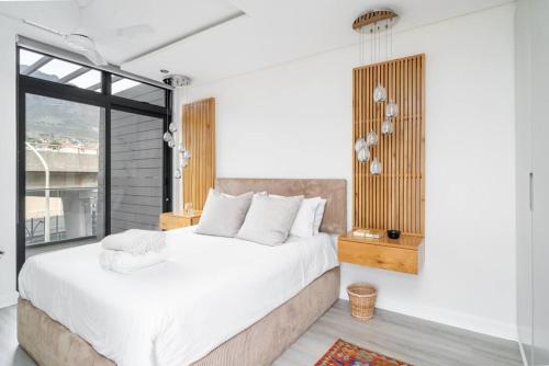 a bedroom with a large bed and a large window at 16 on Sloane in Cape Town
