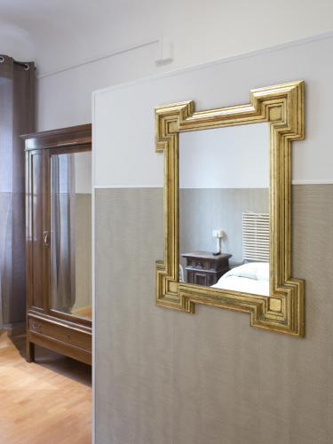 a mirror on the wall of a bedroom at Loggia Fiorentina in Florence
