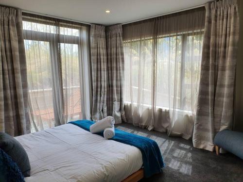 a bedroom with a bed with a teddy bear on it at Beautiful Lake and Alpine Views - Queenstown in Queenstown