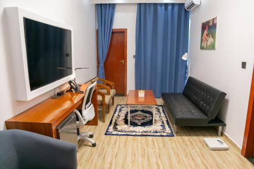 a living room with a tv and a couch and a table at Hotel Totara in Dar es Salaam