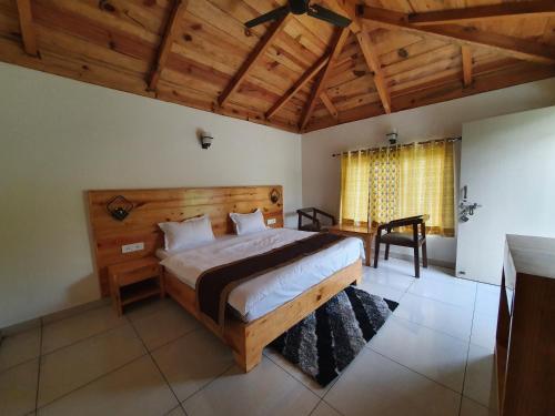 Un dormitorio con una cama grande en una habitación con techos de madera. en The Tiger Claw Resort en Rāmnagar