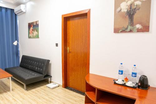 a room with a chair and a table and a door at Hotel Totara in Dar es Salaam