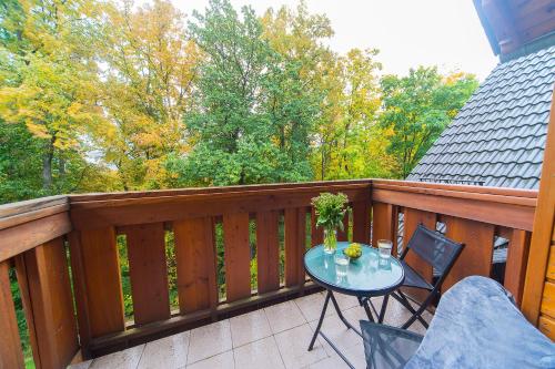 un balcón de madera con mesa y sillas. en Apartamenty Sun Seasons 24 - Leśny Dom, en Karpacz